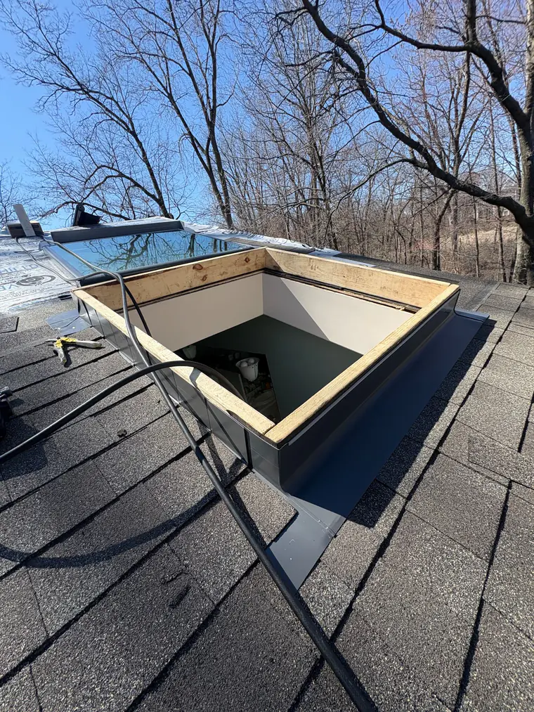 A framed skylight curb with new step flashing waiting for the glass unit.